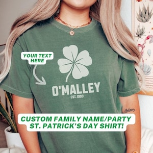 May include: Green t-shirt with a four-leaf clover and the text "O'MALLEY EST. 1993". The text "YOUR TEXT HERE" is written above the clover. The shirt is a custom family name/party St. Patrick's Day shirt.