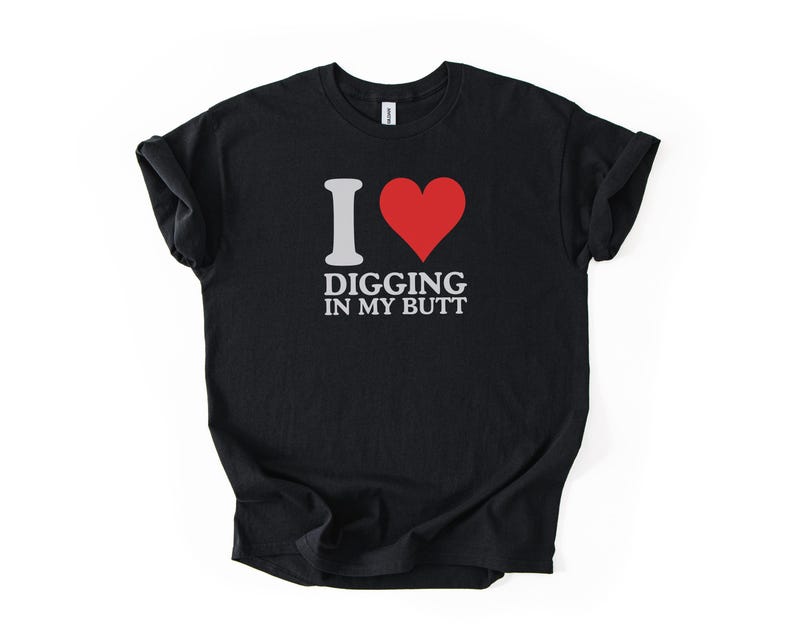 May include: Black t-shirt with the text "I ❤️ Digging in my Butt" in white and a red heart graphic. The shirt is made of a soft material and has short sleeves.