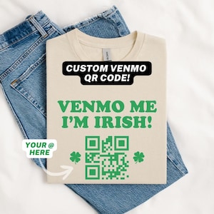 May include: A beige t-shirt with the text "CUSTOM VENMO QR CODE!" and "VENMO ME I'M IRISH!" in green text. A green shamrock is on either side of a black and white QR code. The text "YOUR @ HERE" is in a white box with a green outline.
