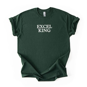 May include: A dark green t-shirt with the text "EXCEL KING" printed in white, centered on the chest. The shirt has rolled-up sleeves and a crew neck, and is displayed on a white background.