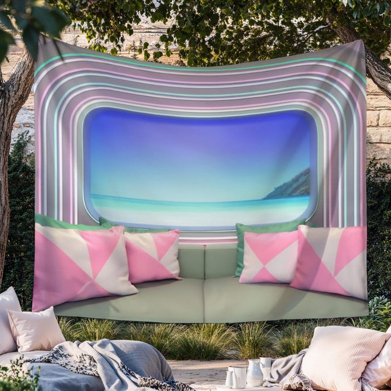 May include: A wall tapestry featuring a central rectangular window view of a calm blue ocean and sky, framed by concentric pastel-colored stripes in shades of pink, teal, and gray, with a printed graphic of a sofa and pink geometric pillows.