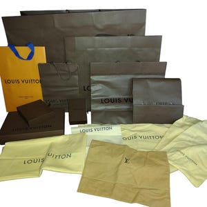 以下が含まれることがあります： ルイ・ヴィトンのショッピングバッグ、箱、ダストバッグのコレクション。バッグは様々なサイズと茶色とタンの色合いで、ブランド名が印刷されています。一部のバッグには青いハンドルが付いています。ダストバッグはベージュ色です。