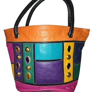 May include: A white ceramic mug with a black handle and the text "But First, Coffee" in a bold, black font. The mug is set against a blurred background, suggesting a cozy setting.