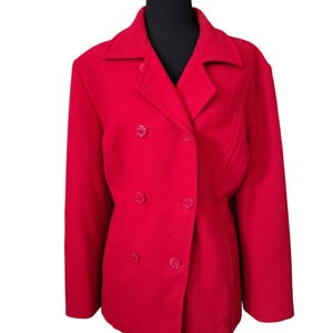 May include: A bright red double-breasted jacket with a classic design. The jacket features a notched collar and six matching buttons. The garment is displayed on a black mannequin, set against a white background.