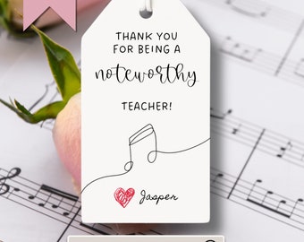 May include: White gift tag with black text that reads "Thank you for being a noteworthy teacher!" with a musical note and a red heart with the name "Jasper" written in black.