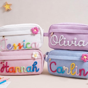 Può includere: Quattro trousse in velluto a coste bianche, rosa, lavanda e blu. Ogni borsa ha un nome ricamato con filo colorato, con un fiore. I nomi sono Jessica, Hannah, Olivia e Carlin.