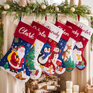 Könnte beinhalten: Sechs Weihnachtsstrümpfe hängen in einer Reihe, jeder mit einem Plüschbündchen, das mit einem Namen bestickt ist: Clark, Viola, Randy, Shaden, Becky und Hunter. Die Strümpfe zeigen festliche Applikationen wie den Weihnachtsmann, einen Baum, einen Pinguin, einen Schneemann, ein Reh und Eisbären.