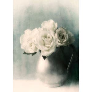 May include: A bouquet of white roses in a silver pitcher against a blue-green background.