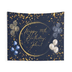 May include: A navy blue tapestry with gold confetti and balloons. The text "Happy 70th Birthday, John!" is in gold script within a gold circle. Clusters of blue, white, and clear balloons are on the tapestry.