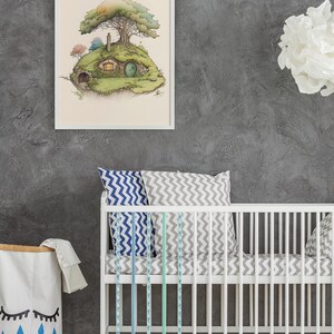 K&ouml;nnte beinhalten: Ein wei&szlig;es Babybett mit einer grau-wei&szlig;en gemusterten Matratze und blauen und gr&uuml;nen gemusterten Bettschutz. An der Wand hinter dem Babybett h&auml;ngt ein wei&szlig; gerahmter Druck eines gr&uuml;nen Hauses mit einem Baum dar&uuml;ber.