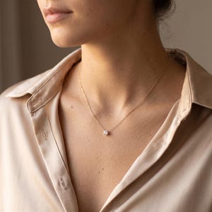 Round cut lab grown diamond solitaire pendant on a fine gold chain with a timeless and elegant look.