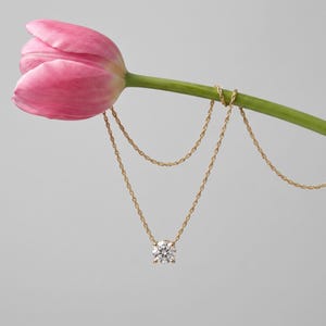 Close-up of a brilliant lab grown diamond pendant necklace in gold with a classic solitaire setting.