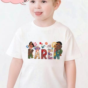 May include: White t-shirt with the name "KAREN" in colorful letters, featuring cartoon characters. The shirt has a custom name and age bubble in the upper left corner.
