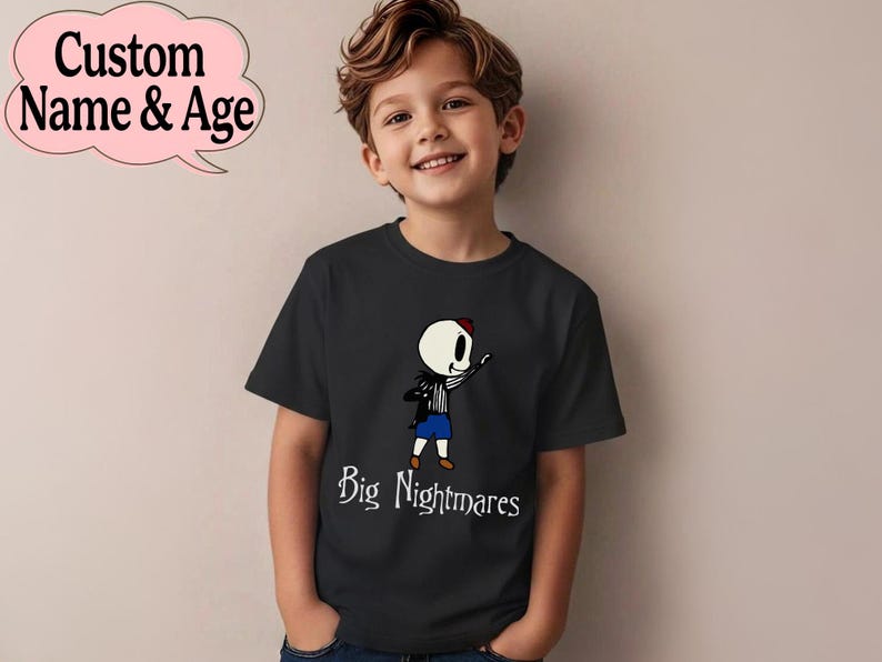 May include: Black t-shirt featuring a cartoon skeleton character with a red hat, black jacket, and blue shorts. The text "Big Nightmares" is below the character. A pink speech bubble with "Custom Name & Age" is in the upper left.