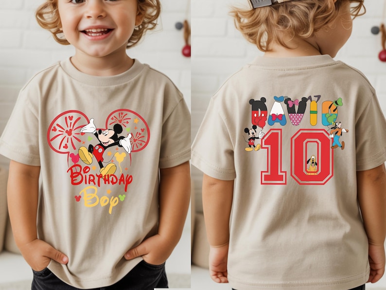 May include: Tan short-sleeve t-shirt featuring Mickey Mouse with the text "Birthday Bop" on the front. The back of the shirt has the number "10" in red, along with various Disney character designs.