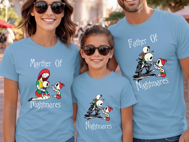 May include: Three light blue t-shirts with matching graphics. The shirts feature the text "Mother Of Nightmares" and "Father Of Nightmares" with a cartoon illustration of characters. The shirts are for a family.