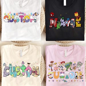 K&ouml;nnte beinhalten: Vier T-Shirts mit individuellen Designs. Ein wei&szlig;es T-Shirt zeigt das Wort "CUSTOM" mit Cartoon-Figuren und Luftballons. Ein schwarzes T-Shirt hat "NAME" mit Marvel-Charakteren. Ein beiges T-Shirt sagt "CUSTOM" mit Monster-Charakteren. Ein rosa T-Shirt sagt "CUSTOM" mit Toy Story-Charakteren.