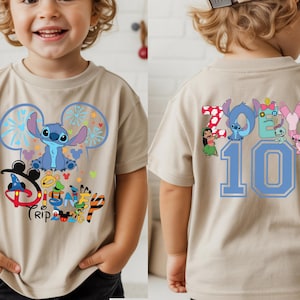 May include: A tan short-sleeved t-shirt with a blue Stitch character design and the words "Disney Trip" on the front. The back of the shirt displays the name "Zoey" and the number "10" in blue.