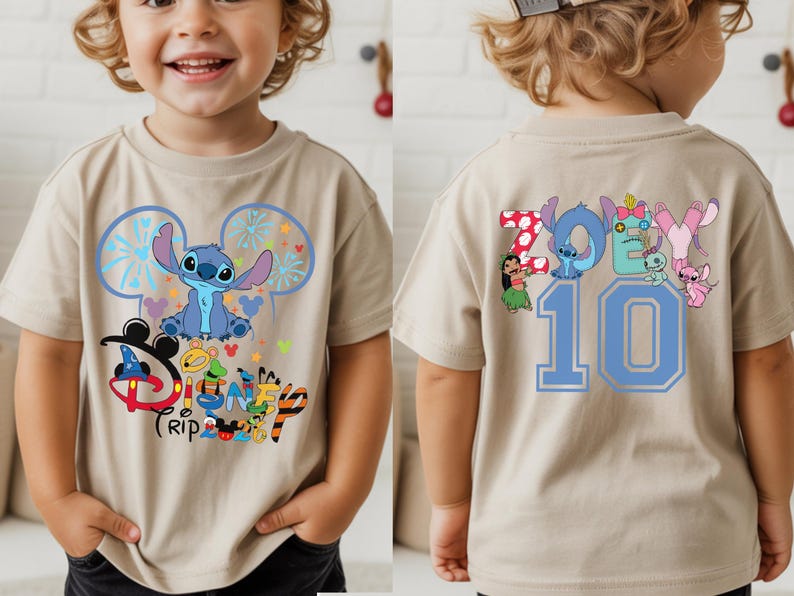 May include: A tan short-sleeved t-shirt with a blue Stitch character design and the words "Disney Trip" on the front. The back of the shirt displays the name "Zoey" and the number "10" in blue.