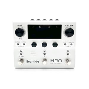 以下が含まれることがあります： 白のEventide H90 Harmonizerエフェクトペダル。ペダルには黒いディスプレイ画面、複数のノブ、フットスイッチがあります。「SELECT」と「PERFORM」の文字がノブの上にあります。「Eventide」と「H90 Harmonizer」の文字が見えます。