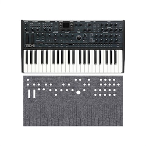 May include: A black Sequential Take 5 synthesizer with a 44-key keyboard, numerous knobs, buttons, and a small display screen, accompanied by a matching grey felt dust cover featuring cutouts for the controls and keys.