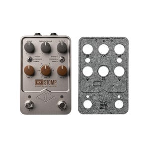 Könnte beinhalten: Ein silberfarbenes Gitarreneffektpedal mit dem Text "OX STOMP. DYNAMIC SPEAKER EMULATOR" und einem Diamantenlogo. Das Pedal hat Knöpfe für "Room", "Speaker Drive", "Output", "Dynamic", "Condenser", "Ribbon" und "Mic 1" und "Mic 2".