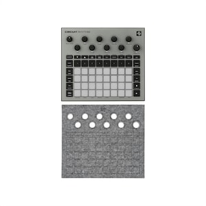 Può includere: Un dispositivo di produzione musicale Circuit Rhythm grigio con più manopole e pulsanti e il testo "CIRCUIT RHYTHM". Sotto, un cuscinetto in feltro grigio con ritagli circolari e quadrati.