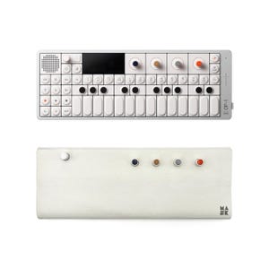 Può includere: Un sintetizzatore bianco con una tastiera nera e una varietà di manopole e pulsanti. Il sintetizzatore ha il testo "OP-1" stampato sul lato. Il sintetizzatore è appoggiato su una custodia in pelle bianca con un piccolo pomello nero sul lato sinistro e quattro piccoli pomelli colorati sul lato destro.