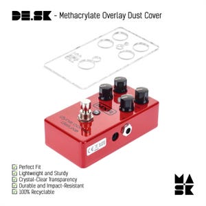 Puede incluir: Un pedal de guitarra rojo MXR Dyna Comp Deluxe con una cubierta antipolvo de plástico transparente. La cubierta antipolvo tiene agujeros para los botones y las tomas del pedal. El pedal tiene un logotipo MXR negro y el texto "Dyna Comp Deluxe" en la parte delantera. El pedal tiene una marca CE en la parte inferior.