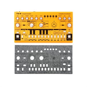 Puede incluir: Un sintetizador Analog Bass Line TD-3 Computer Controlled de color amarillo brillante con numerosas perillas y botones, y un gráfico de carita sonriente. Debajo, un panel de fieltro gris con recortes para los controles del sintetizador.