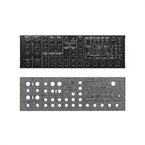 May include: Black synthesizer module with numerous knobs, switches, and labels, along with a gray felt panel with cut-out holes. The synthesizer has the brand name "Behringer" printed on it. The module is rectangular and designed for electronic music production.