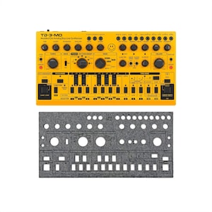 May include: A yellow TD-3-MO Modded Out Analog Bass Line Synthesizer with numerous knobs, buttons, and a smiley face graphic. Below it is a gray felt panel with cut-out holes. The synthesizer has text that reads "TEMPO", "PITCH MODE", "FUNCTION", and "SELECTOR".