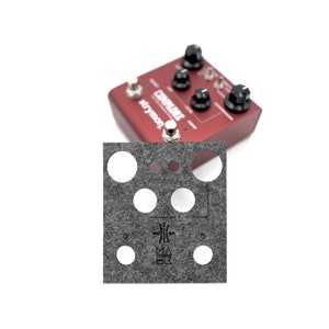 Pode incluir: Um pedalboard de feltro cinza com recortes para pedais de guitarra. O pedalboard tem um logotipo preto com o texto "MAX BK" e um gráfico de uma palheta de guitarra.