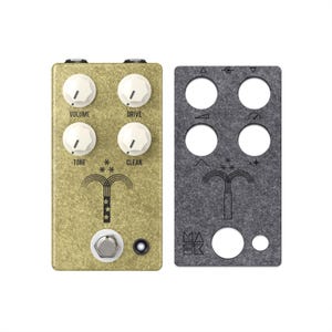 Könnte beinhalten: Ein goldfarbenes Gitarreneffektpedal mit vier weißen Knöpfen: Volume, Drive, Tone und Clean. Es hat einen Fußschalter und eine kleine LED. Daneben befindet sich eine graue Platte mit ausgeschnittenen Kreisen und geätzten Symbolen.