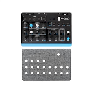 Könnte beinhalten: Schwarzer und blauer Synthesizer mit Knöpfen und der Aufschrift "Protein Synthesizer". Ein grauer Filzausschnitt befindet sich darunter. Der Synthesizer hat eine blaue Basis und weißen Text.