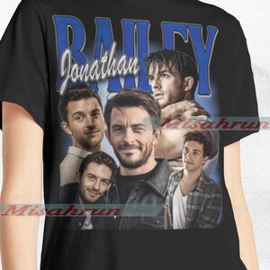 May include: Black t-shirt with a vintage-style graphic featuring four men's faces and the text "Jonathan Bailey".