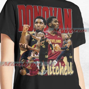 May include: A black t-shirt featuring a vintage-style graphic of basketball player Donovan Mitchell. The graphic shows Mitchell in a Cleveland Cavaliers uniform with the text "Donovan Mitchell" in a yellow and red font.