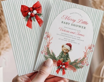 Peut inclure: Deux cartons d'invitation pour une baby shower. L'un présente un nœud rouge avec des baies, l'autre un ours en peluche avec un bonnet de Père Noël et le texte "Merry Little BABY SHOWER". Les invitations ont un fond rayé et sont tenues par une main.