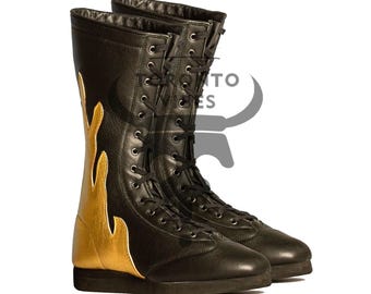 Puede incluir: Un par de botas de cuero negro con un diseño de llama dorada en el lateral. Las botas son con cordones y tienen suela plana. Las botas miden aproximadamente 30 cm de alto.