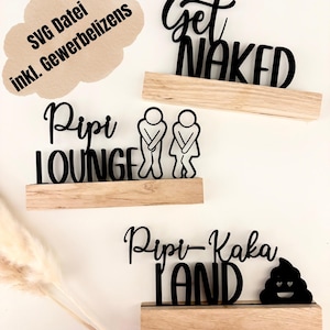 Puede incluir: Carteles de madera negros con frases humorísticas sobre el tema del baño, incluyendo "Get Naked", "Pipi Lounge" y "Pipi-Kaka Land". Cada cartel está montado en una pequeña estantería de madera. También hay una burbuja de pensamiento con texto alemán.
