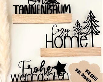 Könnte beinhalten: Drei Holzregale mit schwarzen ausgeschnittenen Wörtern und Weihnachtsbaum-Designs. Die Wörter beinhalten "Oh Tannenbaum", "Cozy Home" und "Frohe Weihnachten". Ein Stern ist im Design "Frohe Weihnachten" enthalten. Das Bild enthält auch den Text "SVG DATEI inkl. Gewerbelizenz".