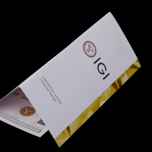 Może przedstawiać: Raport IGI dotyczący hodowanych w laboratorium diament&oacute;w, w kolorze białym i złotym. Raport zawiera logo IGI i słowa "Laboratory Grown Diamond Report".