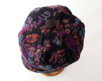 Women's Newsboy Hat in Floral Brocade Jacquard Wool in Black, Purple, Orange, and Blue Jewel Tones