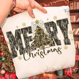 Può includere: Un cuscino bianco con la scritta "MERRY Christmas" in un font mimetico. Un albero di Natale con una stella dorata e un fiocco bianco a pois neri è al centro. Fiocchi di neve e stelle dorate sono sparsi intorno al testo.