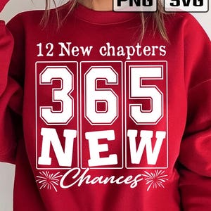 May include: A red sweatshirt with white text. The text reads "12 New chapters 365 NEW Chances". The numbers 365 are in a large, bold font. The word "NEW" is also in a bold font. The sweatshirt has a crew neck.