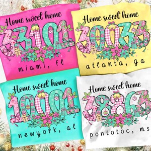 May include: Four brightly coloured t-shirts, each bearing the phrase "Home sweet home" and a different postcode. The designs incorporate festive elements like gingerbread men and bows, with floral accents. The shirts are in pink, yellow, turquoise, and white.