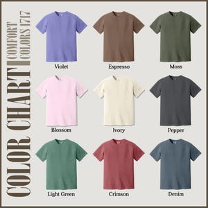 Puede incluir: Una carta de colores con nueve camisetas de manga corta en varios colores lisos. Los colores incluyen violeta, espresso, musgo, flor, marfil, pimienta, verde claro, carmes&iacute; y mezclilla. Tambi&eacute;n se ve el texto "CARTA DE COLORES" y "COLORES CONFORT 1717".