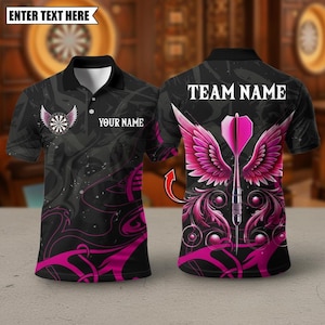 May include: Black polo shirt with a dartboard and wing design. The shirt features a pink and black color scheme with the text "YOUR NAME" on the front and "TEAM NAME" on the back. The design includes a dart with pink wings.
