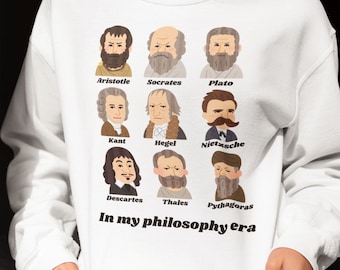 May include: White sweatshirt with a graphic of famous philosophers, including Aristotle, Socrates, Plato, Kant, Hegel, Nietzsche, Descartes, Thales, and Pythagoras. The text "In my philosophy era" is printed below the graphic.