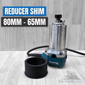 May include: A black rubber reducer shim for a router, with the text "REDUCER SHIM 80MM - 65MM" in blue letters on a white background.